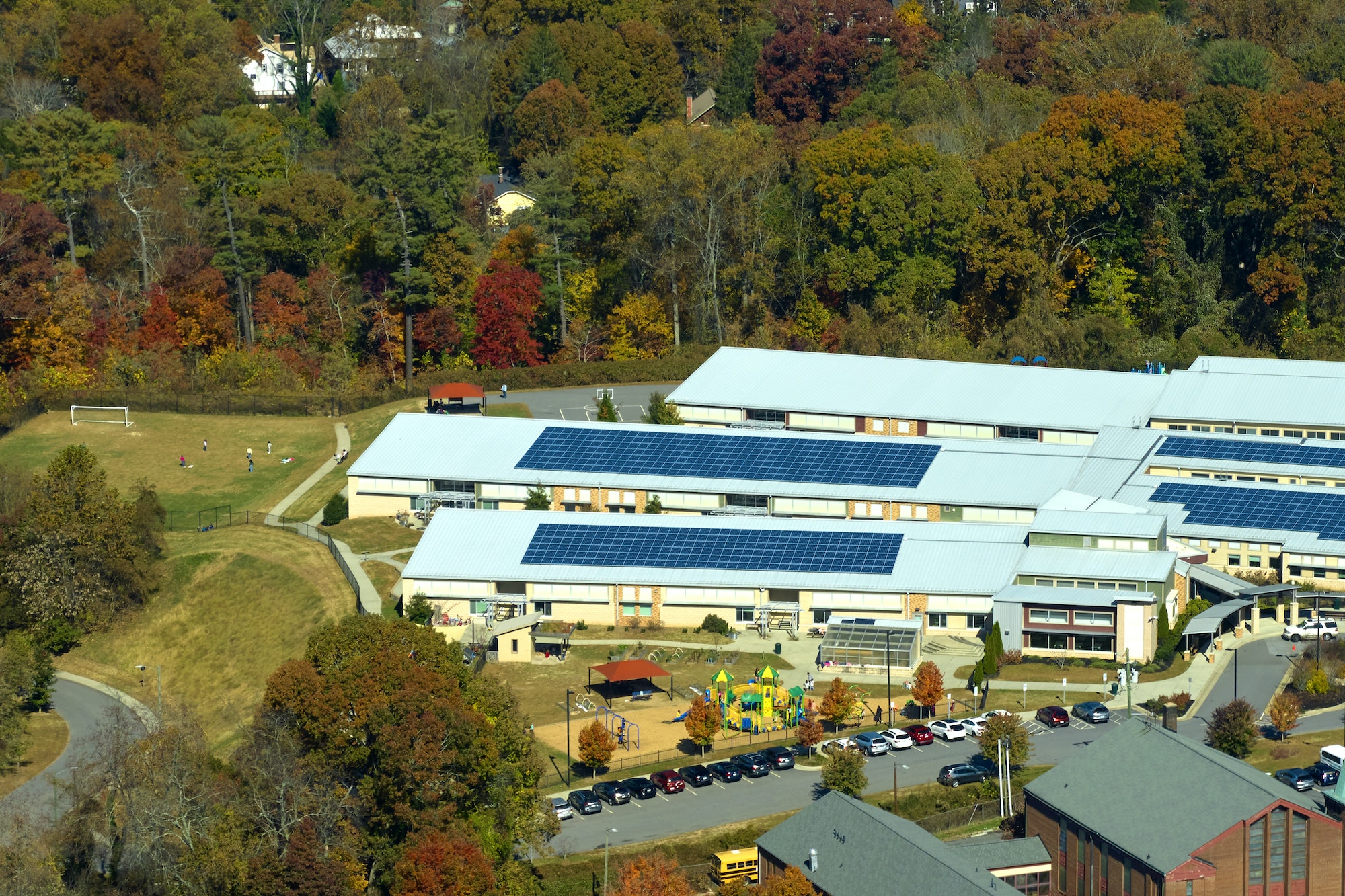 Aerial view of american school building with rooftop covered with photovoltaic solar panels