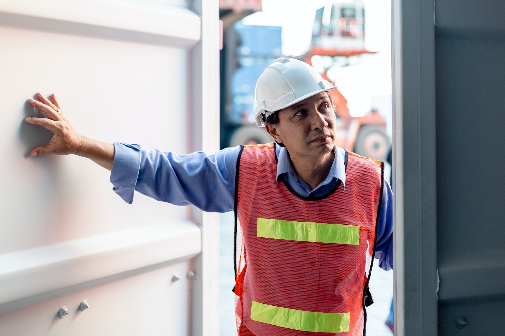 Foreman safety helmet checking containers in cargo ship, Industrial container cargo concept.