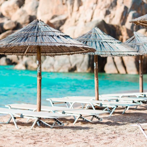 Beach wooden chairs and umbrellas for vacations on beach in Greece