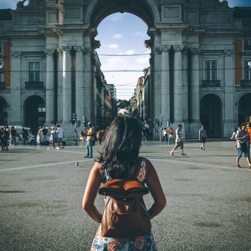 Woman visiting Lisbon. People from behind.